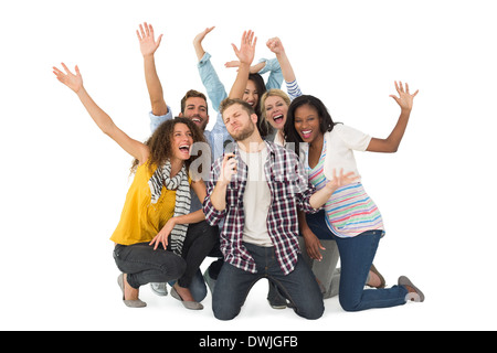 Smiling group of young friends having fun doing karaoke Stock Photo