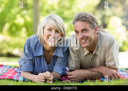 Couple lying on blanket in park Stock Photo