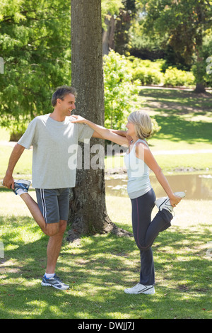 Couple stretching legs in park Stock Photo