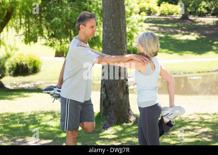 Couple stretching legs in park Stock Photo