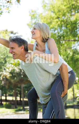 Cheerful mature woman enjoying piggyback ride at beach Stock Photo - Alamy