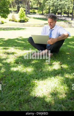 Businessman using laptop outdoors Stock Photo