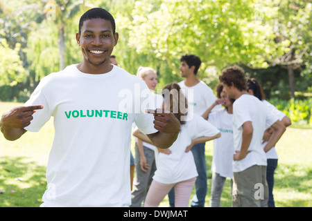Volunteer pointing at tshirt in park Stock Photo