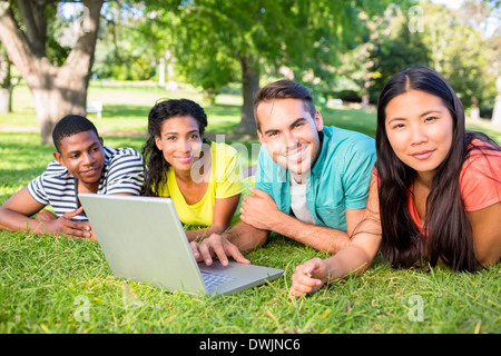 Smiling students with laptop on campus Stock Photo