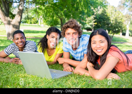 Students with laptop lying on campus Stock Photo