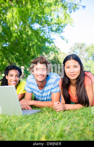 Students with laptop lying on campus Stock Photo