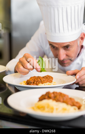 Male chef garnishing food in kitchen Stock Photo