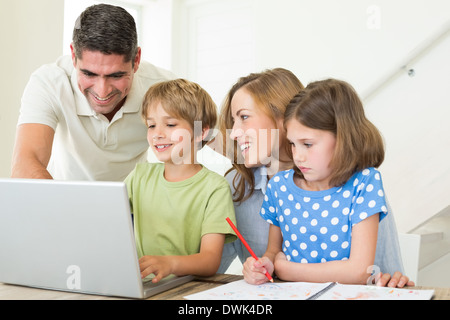 Family using laptop at table Stock Photo