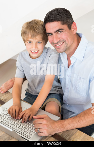Happy father and son using laptop Stock Photo