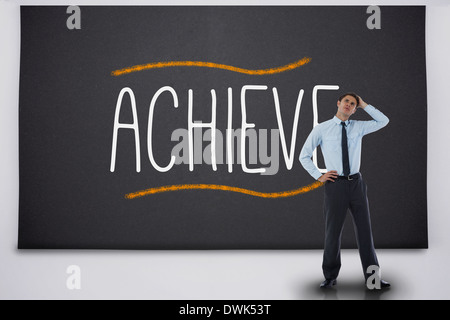 Thinking businessman against the word achieve Stock Photo