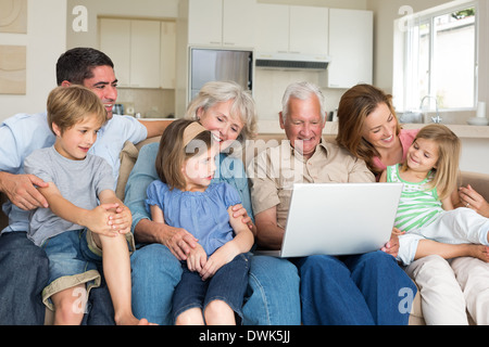 Multigeneration family using laptop in living room Stock Photo