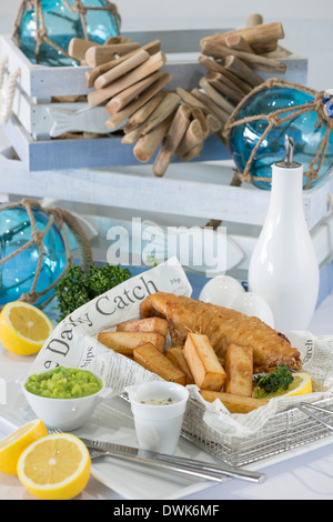 Fish and chips served in a newspaper in a restaurant Stock Photo