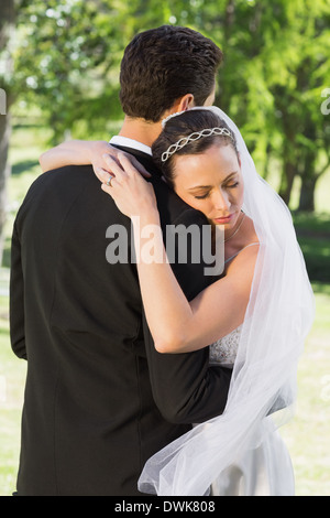 Bride embracing groom on wedding day Stock Photo