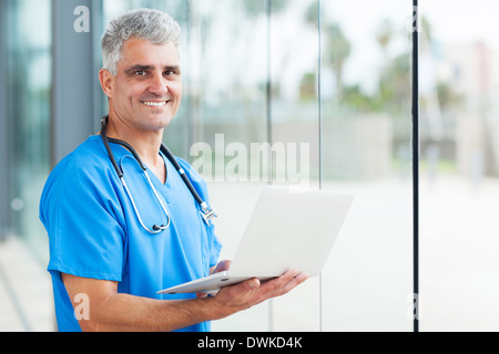 handsome senior male nurse using laptop Stock Photo