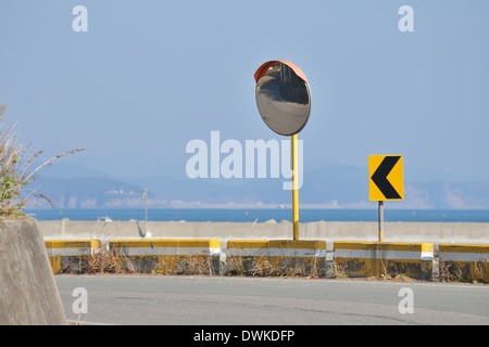 Two Arrow Curve Sign and Convex Mirror on road Stock Photo