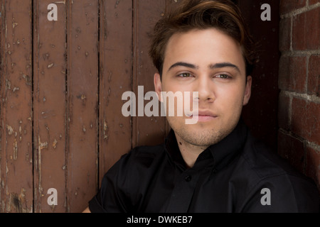 Handsome young caucasian male sitting in a vintage industrial doorway Stock Photo