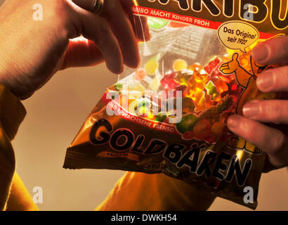 Symbolic picture about sugar in foods: Woman eating gummy bears. Stock Photo