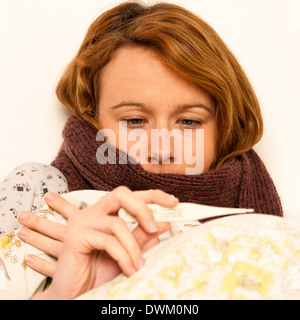 woman checking fever with digital termomether girl with flu resting in bed Stock Photo