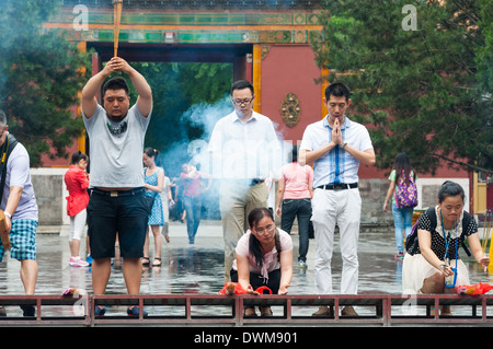 Buddhists burn incense and pray at Yonghegong Lama Temple in Beijing, China. Stock Photo
