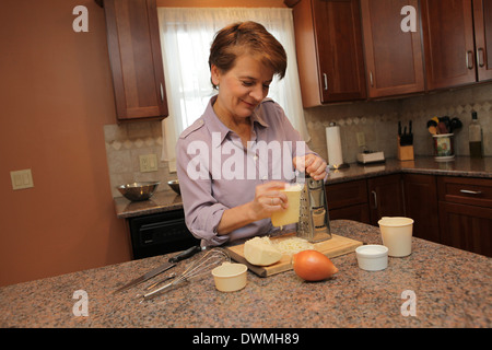 Woman preparing food in her kitchen, New York, USA, © Katharine Andriotis Stock Photo