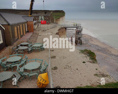 Birling Gap, East Sussex, UK..11 March 2014..Erosion moves ever closer to the National Trust tea rooms, outside sun lounge area closed but business as usual inside, as workmen repair the beach access steps, damaged in the storms. It is hoped that the steps will be reuse able by the end of the week..David Burr/Alamy Live News Stock Photo
