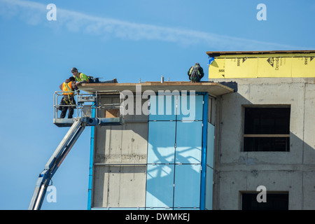 Construction workers and machinery at building construction site-Victoria, British Columbia, Canada. Stock Photo