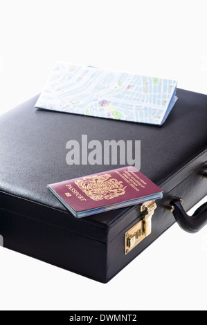 Business persons briefcase with UK passport and street map. Stock Photo