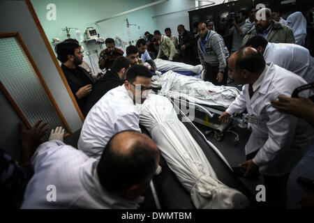 Gaza, Palestinian Territories. 11th Mar, 2014. Palestinian medics check the shrouded bodies of three killed militants from the Islamic Jihad's armed wing, the Al-Quds Brigades, at the hospital morgue before their burial in Khan Yunis following an Israeli air strike in the southern Gaza Strip, on March 11, 2014. An Israeli air strike killed the three militants the territory's Hamas-run health ministry said. Credit:  NurPhoto/ZUMAPRESS.com/Alamy Live News Stock Photo