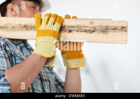 close up of male in gloves carrying wooden boards Stock Photo