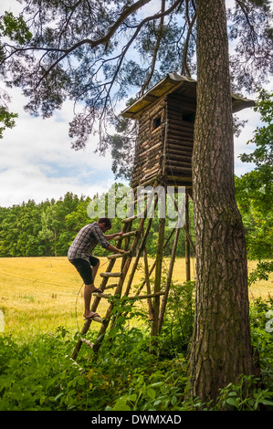 Man climbing on hunter and observation tower Stock Photo