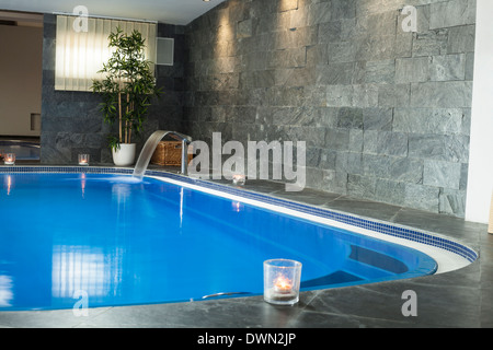 Modern interior design of indoor swimming pool with pool beds, night scene, hotel resort, spa 