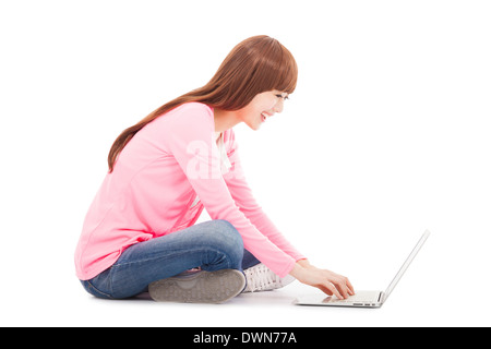 Smiling young woman sitting and typing on a laptop.isolated on white Stock Photo
