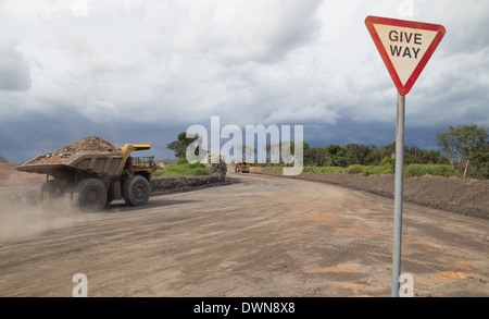 A big yellow Komatsu dump truck carrying 150tons of waste material to a dump whilst a storm begins to form in the background Stock Photo