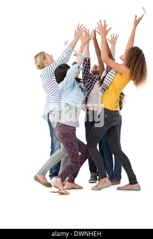 Casually dressed happy young people raising hands Stock Photo