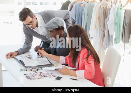 Fashion designers discussing designs in studio Stock Photo