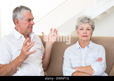 Senior couple sitting on couch having an argument Stock Photo