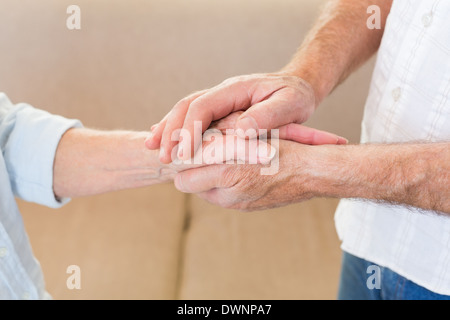 Retired couple touching hands Stock Photo