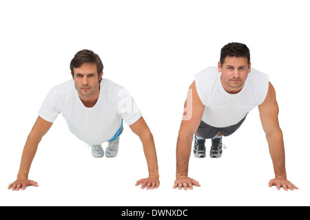 Portrait of two young men doing push ups Stock Photo