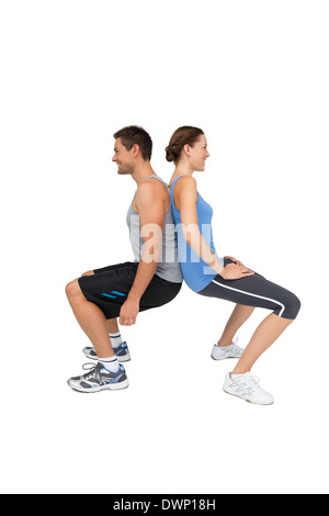 Side view of a fit young couple doing squats Stock Photo