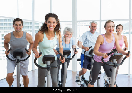 Happy people working out at spinning class Stock Photo - Alamy