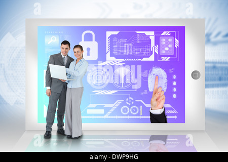 Happy business team using laptop with security interface on tablet Stock Photo