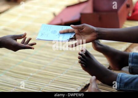 Maxixe, Mozambique. 20th Aug, 2013. The president of the savings group 'Korula', Felizarda Francisco, hands out savings bank books in Maxixe, Mozambique, 20 August 2013. Everyone who wants to make a deposit then hands the money to the treasurer and gives back the savings book. Photo: Britta Pedersen/dpa/Alamy Live News Stock Photo