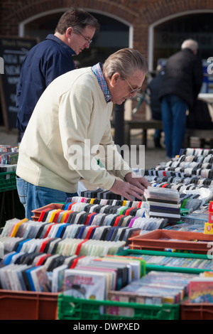 Man searching through DVD's on market stall. Stock Photo