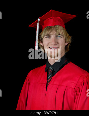 Handsome high school graduate wearing red graduation attire isolated on black Stock Photo