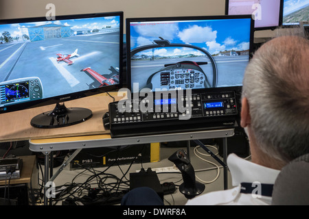 Man navigating virtual plane in amateur flight simulator on home computer Stock Photo