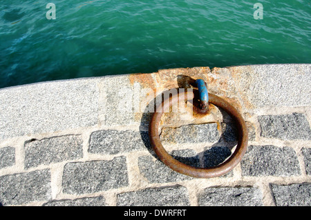 metallic and rusty mooring ring on dock Stock Photo