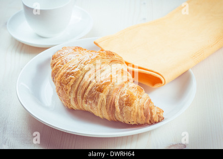 Fresh croissant on a plate. Toning in vintage style Stock Photo