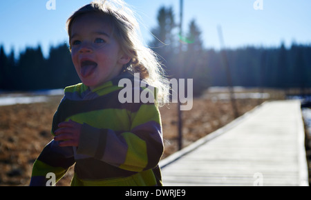 Girl running along wooden decking pathway Stock Photo