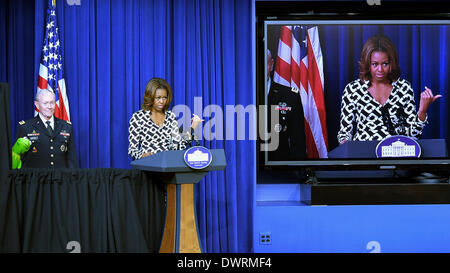 Washington, DC, USA. 12th Mar, 2014. U.S. First Lady Michelle Obama, accompanied by Kermit the Frog, speaks at a special screening of Disney's movie Muppets Most Wanted at the White House in Washington, DC, capital of the United States, March 12, 2014. As part of the Joining Forces initiative, First Lady Michelle Obama delivered remarks to children of military families during the special screening. Credit:  Bao Dandan/Xinhua/Alamy Live News Stock Photo