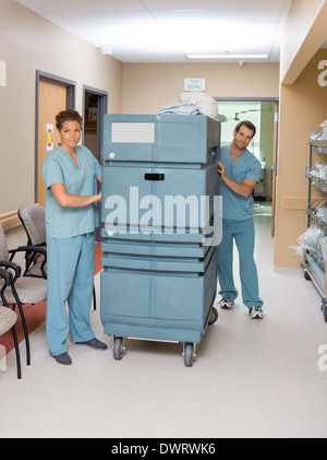 Nurses Pushing Trolley In Hospital Hallway Stock Photo